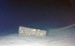 Some type of box or sea locker lying next to the ship.