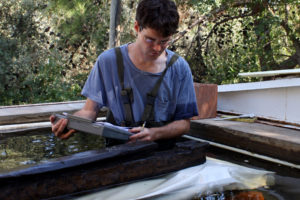 Michael Jones cataloging the main keel timber of YK 14 in the freshwater storage tanks at INA’s Bodrum Research Center. (Photo: INA). REF4809